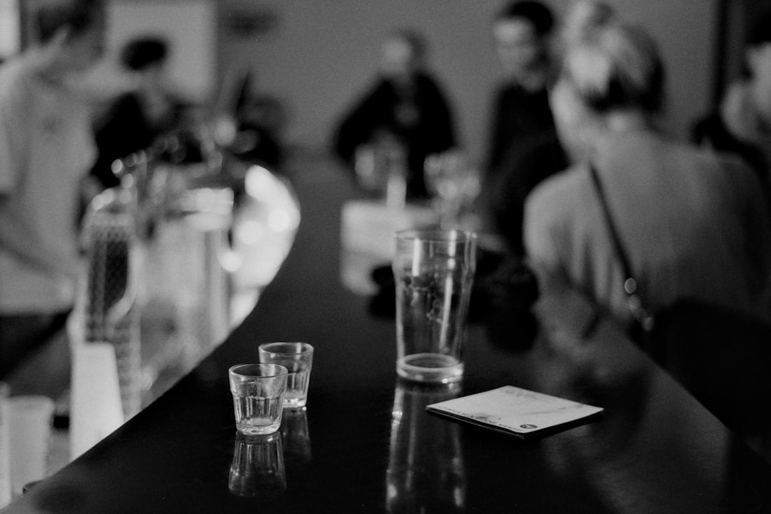a black and white photo of people at a bar